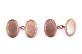 A pair of 9ct gold cufflinks. Of oval form with engraved decoration around the rims, L18mm, 8.