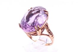 A 9ct gold amethyst dress ring. The stone of oval form, in a pierced mount, size J, 4.
