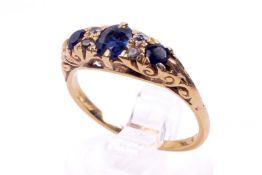 A yellow metal dress ring. Set with three faceted sapphires of 0.