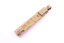 A 9ct gold ingot. Of cylindrical form with a textured exterior, L57mm, 27.