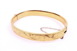 A yellow metal hinged bangle.