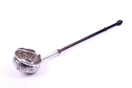 A white metal toddy ladle.