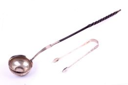 A white metal toddy ladle and a pair of Georgian sugar tongs.