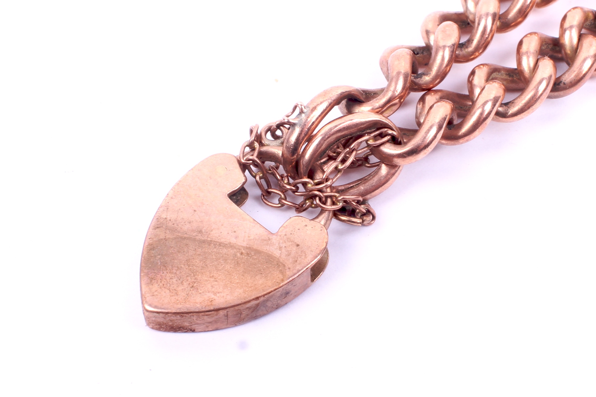 A rose coloured metal curb link bracelet. With padlock and safety chain fittings. Marked '9ct'. - Image 2 of 2