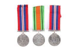 Three WWII military medals in 2 boxes, unmarked.