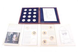 A group of eighteen gold plated enamelled medallions of Philip Duke of Edinburgh in a box and