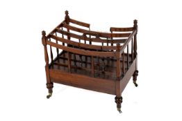 A Canterbury magazine rack. With a drawer beneath raised on brass casters.