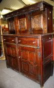 A 20th century carved oak court cupboard. A series of carved and panelled doors with two drawers.