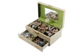 A gilt cream jewellery box of assorted costume jewellery.