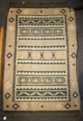 A Kilim woollen rug. Geometric patterns in brown and beige.