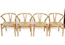 A set of four contemporary unbranded blonde wood framed open armchairs.