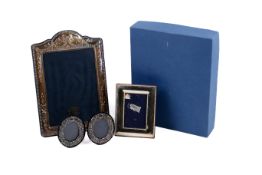 Three silver hallmarked picture frames and a plated frame.