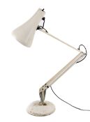 An Anglepoise cream coloured desk lamp. On a circular base.