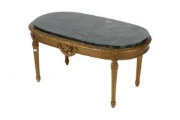 A marble top gilt table. With carved floral motifs and flowers, over column legs, with swag detail.