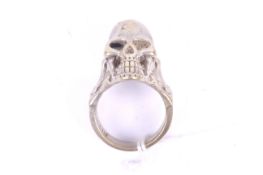 A large skull and bones white metal ring. Marked silver in Chinese, size W, weight 20.9g.