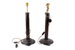 Pair of fluted wooden column table lamps. Raised on round bases with three bun feet.