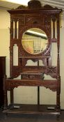 A circa 1900 carved oak hall stand. Carved with floral motifs with brass coat hooks.
