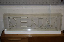 Neon 'Denim' sign. In a Perspex case. H 36cm W 100cm.