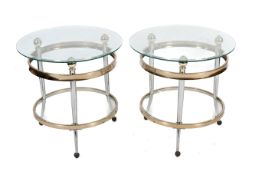 Pair of glass top coffee tables. Of gilt metal circular form with three supports and a lower shelf.