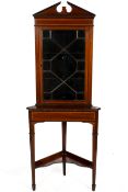 A mahogany corner cabinet. With glazed door on stand, opening to reveal two shelves H190cm.