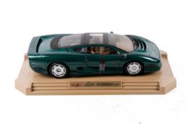 A Maisto Jaguar XJ220 (1992) diecast scale model in green.
