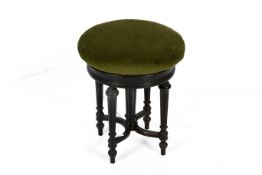 A carved ebonized base circular green velvet upholstered stool.