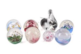 A collection of seven assorted glass paperweights and a Murano swan.