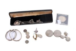 A group of silver jewellery and a few coins.