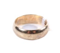 A 9ct gold wedding band. Of slight convex form, size M, weight 4.4g.