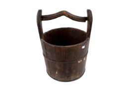 A rustic wooden well bucket.