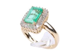 A yellow gold emerald and diamond cluster ring. The emerald cut emerald of 1.