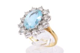 A yellow gold aquamarine and diamond cluster ring. The oval faceted aquamarine of 2.