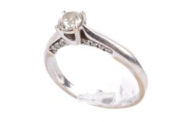 A diamond solitaire ring. The round modified brilliant cut diamond of 0.