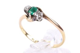 An 18ct gold emerald and diamond twist set ring.
