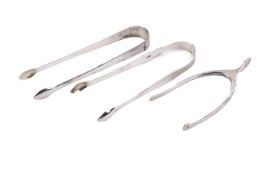 Three silver sugar tongs.
