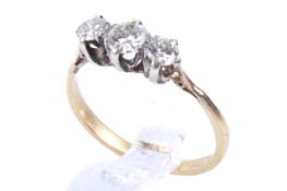 A gold and three stone diamond ring. Set with three round brilliant cut diamonds of circa 0.