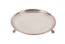 A small silver salver. With beaded borders over ball and claw feet.