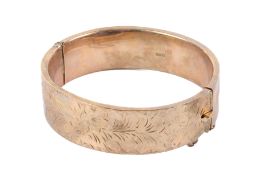 A 9ct gold hinged bangle. Hollow, one half engraved with flowers and leaves, width 1.