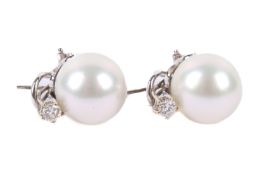 A pair of diamond and pearl earrings. Each set with one cultured South Sea pearl of 14.3 - 14.