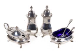 An early 20th century four piece silver condiment set with two spoons.