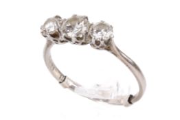 A three stone white metal diamond ring. Set with three round brilliant cut diamonds of 1.