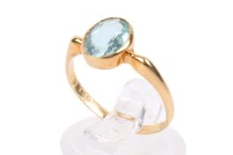 A single stone ring set with an oval faceted aquamarine. The stone circa 1.