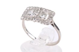 A 20th century diamond and white metal panel ring. Set with two old square cut diamonds of circa 0.