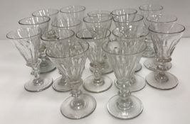 Seventeen 19th Century facet cut glasses with trumpet shaped bowls on knop stems and circular feet