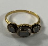 A Georgian gold three stone diamond ring, the emerald cut stones within an illusion setting,
