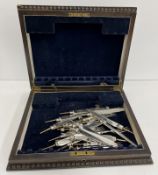 A set of twelve silver fruit knife blades and fork prongs and ferrules (handles removed) with oak
