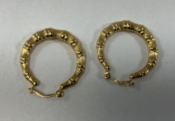 An 18-carat gold pair of hoop earrings of bone form,