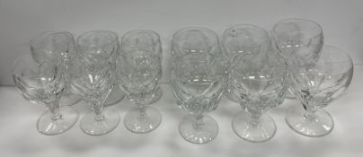 A set of six facet cut glass red wines on circular bases together with a matching set of six white