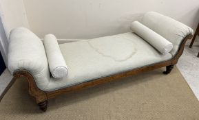 A Victorian mahogany and penwork decorated upholstered scroll arm window seat raised on ringed and