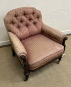 A Victorian button back salon chair with carved show frame raised on turned,